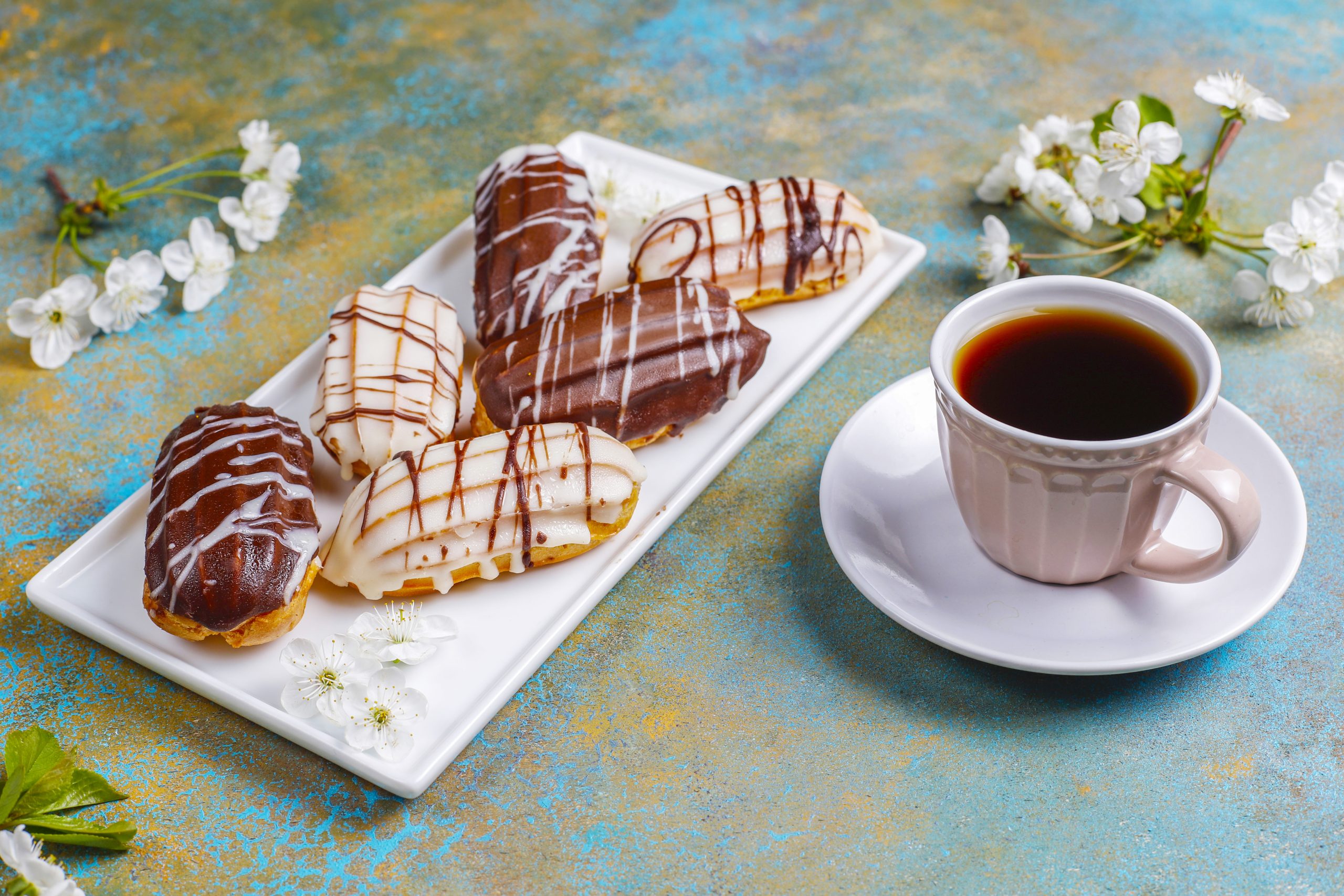 Eclairs or profiteroles with black chocolate and white chocolate